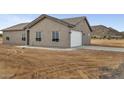 Exterior of the home with an attached garage, showcasing the neutral color scheme and desert surroundings at 22352 W Gamble Ln, Wittmann, AZ 85361