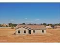 Front exterior of a single-story home with a simple, clean design and natural desert surroundings at 22352 W Gamble Ln, Wittmann, AZ 85361