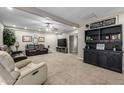 Comfortable living room with neutral carpet, a ceiling fan, and a built-in bookshelf at 253 N Fraser Dr, Mesa, AZ 85203