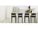 Modern kitchen bar area featuring sleek black chairs, white cabinets, and ample counter space at 3139 E Barrel Race Rd, San Tan Valley, AZ 85140
