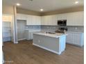 Modern kitchen boasts white cabinets, center island, stainless steel appliances, and ample counter space at 31878 N Bandit Rd, San Tan Valley, AZ 85143