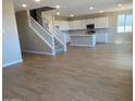 Spacious open floor plan features new wood-look flooring, stairs, and kitchen with a center island at 31878 N Bandit Rd, San Tan Valley, AZ 85143