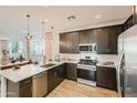Modern kitchen with stainless steel appliances, sleek countertops, and a convenient breakfast bar seating area at 38233 N Stillmeadow Rd, San Tan Valley, AZ 85140