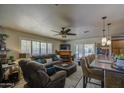 Open-concept living area showcases a ceiling fan, fireplace, plush seating, and seamless flow to the kitchen at 5119 N 87Th St, Scottsdale, AZ 85250