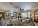 Inviting living room with tile floors, ceiling fan, neutral paint, and abundant natural light from large windows at 5119 N 87Th St, Scottsdale, AZ 85250