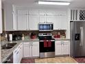 Modern kitchen featuring white cabinetry, stainless steel appliances, and granite countertops at 6049 S Wilson Dr, Chandler, AZ 85249