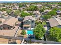 Backyard featuring a private pool, cozy seating, and well-maintained landscaping with shade trees at 6321 W Gross Ave, Phoenix, AZ 85043