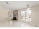 Living room with brick fireplace, white marble floors, and built-in shelves at 643 W Medina Ave, Mesa, AZ 85210