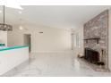 Bright living room featuring a brick fireplace, white marble floors, and modern lighting at 643 W Medina Ave, Mesa, AZ 85210