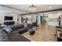 Spacious living room with mirrored wall, plush seating, and hardwood floors, blending style and comfort at 7707 E Earll Dr, Scottsdale, AZ 85251