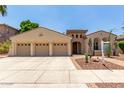 Beautiful desert home with three-car garage, desert landscaping, and lovely arched entryway at 915 W Orchard Ln, Litchfield Park, AZ 85340