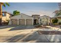 Charming desert home with a large three car garage, beautiful desert landscaping and sunset at 915 W Orchard Ln, Litchfield Park, AZ 85340