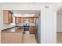 Well-lit kitchen featuring stainless steel appliances, wood cabinets and a skylight at 925 S Longmore -- # 201, Mesa, AZ 85202