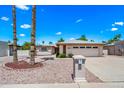 Charming single-story home with a well-maintained landscape and attached garage, showcasing its inviting curb appeal at 9654 E Foster Ave, Sun Lakes, AZ 85248