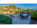 Resort-style backyard featuring a pool, spa, lush landscaping, and outdoor dining area at 10207 W Hedge Hog Pl, Peoria, AZ 85383