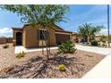 Inviting single-story home with desert landscaping, a two-car garage, and mature trees at 128 S 200Th Ave, Buckeye, AZ 85326