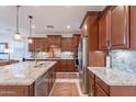 Gorgeous kitchen with dark cabinets, granite countertops, and stainless steel appliances at 13719 W Amberwing St, Peoria, AZ 85383