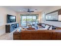 Cozy living room with plush leather seating and sliding doors to the pool area at 13719 W Amberwing St, Peoria, AZ 85383