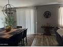 A dining room with a wooden table, black chairs, modern lighting, and a sliding glass door at 1418 E Jacqueline Pl, Casa Grande, AZ 85122