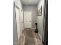 Hallway with a decorative rug, gray walls, and several white doors with black hardware at 1418 E Jacqueline Pl, Casa Grande, AZ 85122