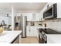 Updated kitchen featuring stainless appliances, white cabinets, quartz countertops, and modern backsplash at 1425 E Diamond St, Phoenix, AZ 85006