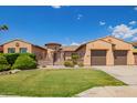 Inviting single-story home with a lush green lawn and a convenient two-car garage at 14372 W Cypress St, Goodyear, AZ 85395
