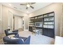 Bright home office featuring custom shelving, stylish desk, comfortable chairs, and a neutral color palette at 14825 W Whitehorn Way, Surprise, AZ 85387