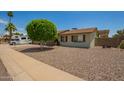 Charming home featuring a xeriscaped front yard, mature tree, and neutral color palette at 19031 N 13Th Dr, Phoenix, AZ 85027
