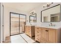 Modern bathroom featuring double vanities, sleek fixtures, and a sliding glass door to the patio at 1955 Leisure World --, Mesa, AZ 85206