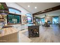 Open concept kitchen with wood island, farm sink, and large windows with view to the colorful flower garden outside at 22364 N 59Th Ln, Glendale, AZ 85310