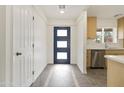 Bright foyer with a modern front door, updated flooring, and adjacent kitchen with stainless steel appliances at 224 N 58Th St, Mesa, AZ 85205