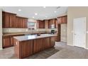 Kitchen with central island, granite countertops, dark wood cabinetry, stainless steel appliances, and tile flooring at 2620 E Rustling Oaks Ln, Phoenix, AZ 85024