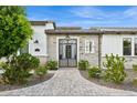 Elegant home entrance featuring a secure metal gate, brickwork and verdant shrubbery at 4024 E Minton Cir, Mesa, AZ 85215