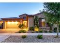 Charming single-Gathering home featuring a stone facade, a two-car garage, and well-maintained landscaping at twilight at 5328 S Wesley Cir, Mesa, AZ 85212