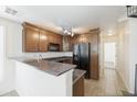 Cozy kitchen features wooden cabinets, granite countertops, black appliances, and a convenient breakfast bar at 5749 S 21St Ter, Phoenix, AZ 85040