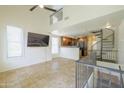 Bright living room features tile floors, a spiral staircase, and an open layout connecting to the kitchen at 5749 S 21St Ter, Phoenix, AZ 85040