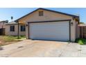 A single-story home with an attached garage, concrete driveway, and low maintenance yard with a small tree at 8051 W Mariposa Dr, Phoenix, AZ 85033