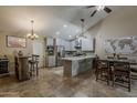 Open-concept kitchen and dining area with stainless appliances, tile backsplash, and modern lighting fixtures at 9196 E Evans Dr, Scottsdale, AZ 85260