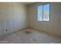 A bright bedroom under construction featuring a new window and walls prepped for paint at 9531 W Parkway Dr, Tolleson, AZ 85353