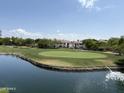 Picturesque golf course view featuring a green, lake, and residential buildings in the background at 9649 S 51 St St, Phoenix, AZ 85044