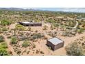 Secluded estate featuring custom home, outbuildings, and natural desert landscaping with mountain views in the distance at 10600 E Cordova St, Gold Canyon, AZ 85118
