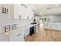 Bright kitchen boasts white cabinets, new appliances, marbled countertops, and a wine fridge for added convenience at 10839 W Peoria Ave, Sun City, AZ 85351