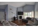 Cozy living room features hardwood floors, a fireplace, a comfortable sectional sofa, and ample natural light at 1117 W Manor St, Chandler, AZ 85224
