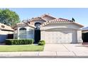 Inviting single-Gathering home showcases a two-car garage, verdant lawn, and trimmed hedges beneath a clear blue sky at 1463 E Silver Creek Rd, Gilbert, AZ 85296