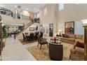 Spacious living room with tall ceilings, grand staircase, and plenty of natural light at 17728 N 92Nd Pl, Scottsdale, AZ 85255