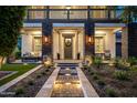 Inviting front entrance with stone accents, a well-manicured lawn, and stylish outdoor seating at 20866 W Werner Pl, Buckeye, AZ 85396