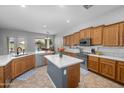 Bright kitchen featuring wood cabinetry, stainless steel appliances, a center island, and views of the backyard pool at 2270 E Indian Wells Dr, Chandler, AZ 85249