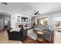 Cozy living room with a fireplace, built-in shelving, comfortable seating, and sliding doors to the outdoor patio at 2270 E Indian Wells Dr, Chandler, AZ 85249