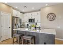 Modern kitchen features white cabinets, stainless steel appliances, and a large island with bar seating at 23225 N Hank Raymond Dr, Sun City West, AZ 85375