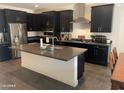 Modern kitchen with stainless steel appliances, dark cabinetry, gray countertop, and a large island at 2364 N 212Th Ave, Buckeye, AZ 85396